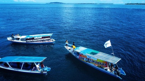 Walhi NTB aksi di tengah laut pantai Sire Kecamatan Pemenang Lombok Utara untuk peringati Hari Bumi, Minggu (30/4/2023). Foto: Ahmad Viqi/detikBali.