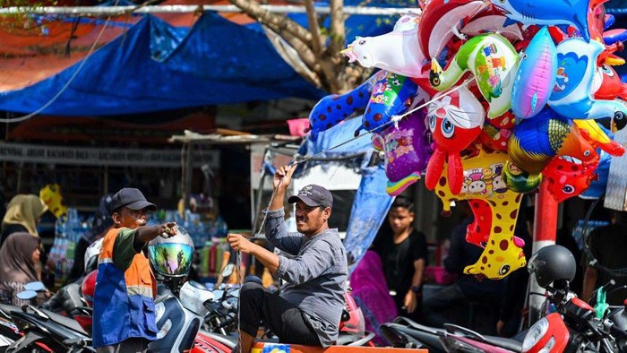 A man sell balloons during the International Labour's Day in Banda Aceh on May 1, 2023. (Photo by CHAIDEER MAHYUDDIN / AFP) (Photo by CHAIDEER MAHYUDDIN/AFP via Getty Images)