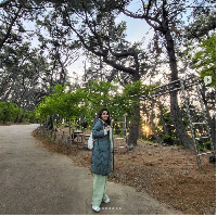 Menikmati taman di kota Busan, Ayu Ting Ting bergaya dengan one set berwarna hijau. Dia memakai jaket parka yang dipadukan dengan sneakers putih dan tas ransel. Foto: Dok. Instagram Ayu Ting Ting