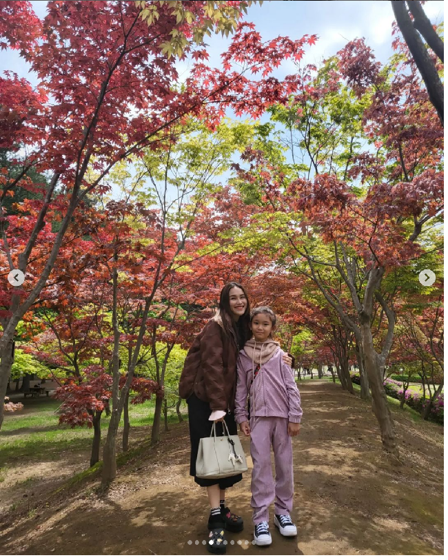 Menikmati keindahan Nami Islad bersama Bilqis, Ayu Ting Ting tampil dengan rok midi dan jaket untuk menahan udara dingin di Korea Selatan yang tengah memasuki musim semi.  Foto: Dok. Instagram Ayu Ting Ting