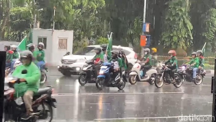 Sebagian Buruh yang nekat melanjutkan aksi unjuk rasa di tengah hujan di kawasan Ahmad Yani menuju Basuki Rahmat Surabaya