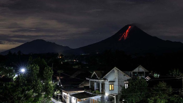Gunung Merapi Sambul Awal Mei dengan Lava Pijar A man rides a motorcycle past a river, while Mount Merapi, a volcanic mountain spews volcanic material in South Kaliurang village, Srumbung district in Central Java, Indonesia on April 30, 2023. Merapi is located in one of the most densely populated parts of Java with over 11,000 people living on the slopes of the mountain. Mount Merapi, measuring 2,968 metres high, is known as one of the most active volcanoes in Indonesia, with an eruption occurring every two to five years. (Photo by Garry Lotulung/NurPhoto via Getty Images)