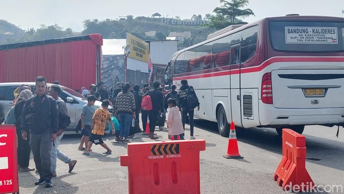 Pemudik berebut naik bus di Rest Area Tol Purbaleunyi KM 125, Senin (1/5/2023).