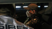 Peneliti dari Badan Riset dan Inovasi Nasional (BRIN) Andi Pangerang Hasanuddin (tengah) berada di dalam mobil kepolisian setibanya di Terminal 2 Bandara Soekarno, Hatta, Tangerang, Banten, Minggu (30/4/2023).