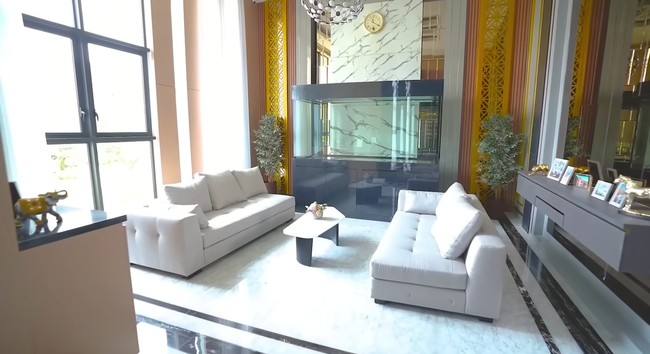 Dokter pemilik klinik kecantikan Athena itu kemudian memperlihatkan area ruang tamu yang disebutnya dimodifikasi puluhan kali. Tampak dua sofa besar menghiasi ruangan tersebut. Dan yang tampak menonjol ada akuarium kosong. Menurut dr. Richard Lee dia akan mengisi akuarium tersebut dengan ikan hiu. Pengakuannya ini jadi kontroversi sebab akuarium bukanlah habitat ikan hiu. Foto: Dok. YouTube dr. Richard Lee