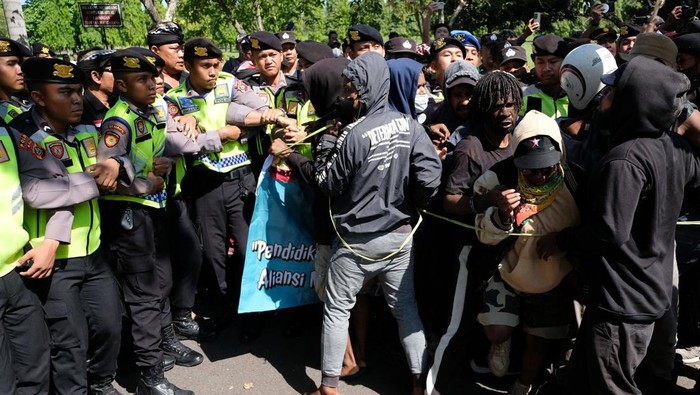 Polisi dan pecalang memukul mundur massa dari Aliansi Mahasiswa Papua (AMP) saat unjuk rasa dari dua kelompok massa yang bertepatan dengan Hari Buruh Internasional di Denpasar, Bali, Senin (1/5/2023). Polisi dibantu Babinsa TNI AD, Satpol PP dan Pecalang atau satuan pengamanan desa adat Bali berupaya membubarkan unjuk rasa yang ricuh itu. ANTARA FOTO/Nyoman Hendra Wibowo/foc.