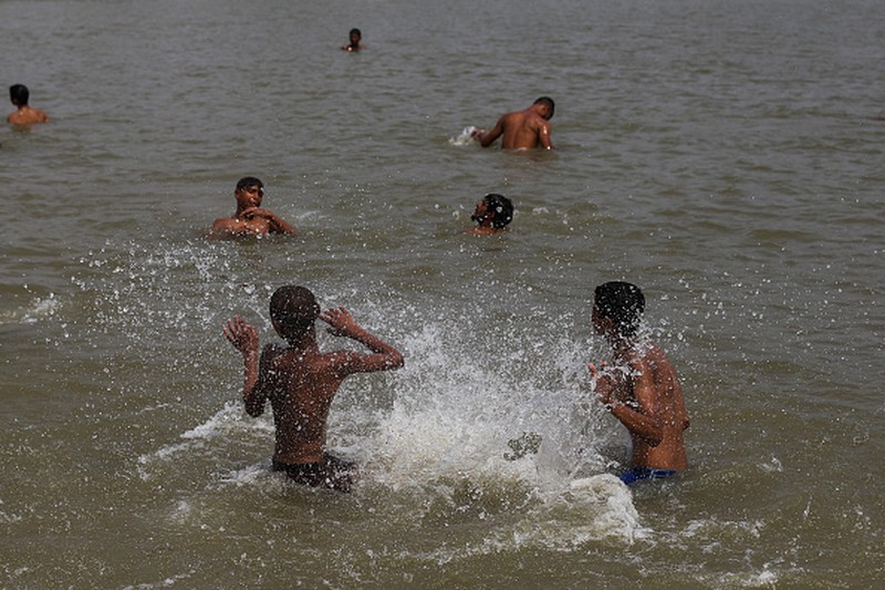 NEW DELHI, INDIA - 2022/06/12: People walk past Akshardham temple on a hot day in New Delhi. Temperatures in the Indian capital soared to above 44 degrees celcius. A heatwave is declared when the maximum temperature is over 40 degrees celsius. (Photo by Pradeep Gaur/SOPA Images/LightRocket via Getty Images)