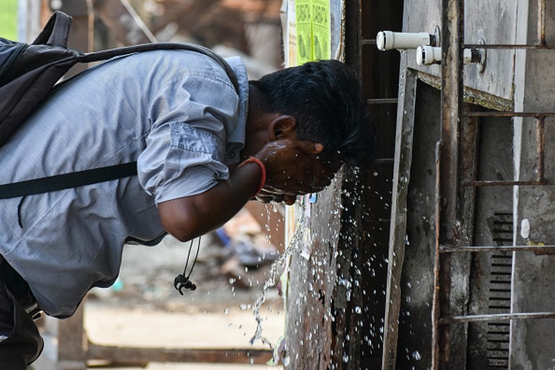 NEW DELHI, INDIA - 2022/06/12: People walk past Akshardham temple on a hot day in New Delhi. Temperatures in the Indian capital soared to above 44 degrees celcius. A heatwave is declared when the maximum temperature is over 40 degrees celsius. (Photo by Pradeep Gaur/SOPA Images/LightRocket via Getty Images)