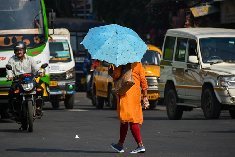 NEW DELHI, INDIA - 2022/06/12: People walk past Akshardham temple on a hot day in New Delhi. Temperatures in the Indian capital soared to above 44 degrees celcius. A heatwave is declared when the maximum temperature is over 40 degrees celsius. (Photo by Pradeep Gaur/SOPA Images/LightRocket via Getty Images)