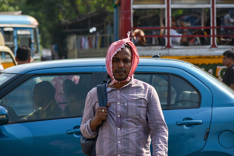 NEW DELHI, INDIA - 2022/06/12: People walk past Akshardham temple on a hot day in New Delhi. Temperatures in the Indian capital soared to above 44 degrees celcius. A heatwave is declared when the maximum temperature is over 40 degrees celsius. (Photo by Pradeep Gaur/SOPA Images/LightRocket via Getty Images)