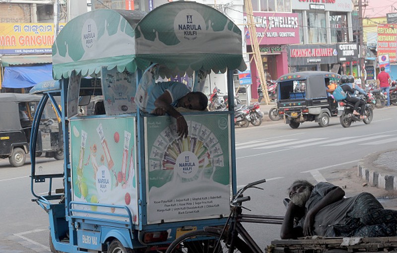 NEW DELHI, INDIA - 2022/06/12: People walk past Akshardham temple on a hot day in New Delhi. Temperatures in the Indian capital soared to above 44 degrees celcius. A heatwave is declared when the maximum temperature is over 40 degrees celsius. (Photo by Pradeep Gaur/SOPA Images/LightRocket via Getty Images)