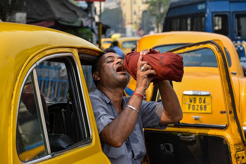 A taxi driver is seen drinking water from a bottle during afternoon heat in Kolkata , India , on 18 April 2023 . Temperature sore well above 40 Celsius as IMD has announces that heat wave will continue till the end of late on the second week of April as India experiences its highest temperature of April in nearly a decade according to report. (Photo by Debarchan Chatterjee/NurPhoto via Getty Images)