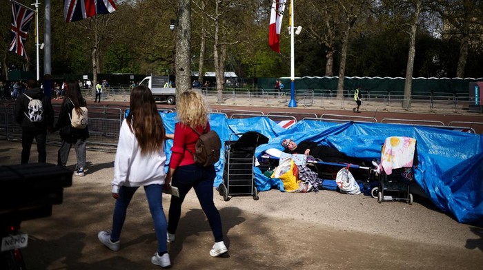 Aksi Fans Keluarga Kerajaan Berkemah Jelang Penobatan Raja Charles III Royal fan John Loughrey lies down as he poses for members of the media on The Mall, outside Buckingham Palace, where he has set up camp ahead of the Coronation of King Charles and Camilla, Queen Consort, in London, Britain, April 30, 2023. REUTERS/Henry Nicholls