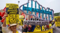 Anggota organisasi sosial Salvador memegang tanda sebagai protes terhadap pemerintah Salvador dan rezim pengecualian, selama demonstrasi sebagai bagian dari Hari Buruh Internasional di San Salvador, El Salvador, Senin (1/5/2023). (APHOTOGRAFIA/Getty Images)