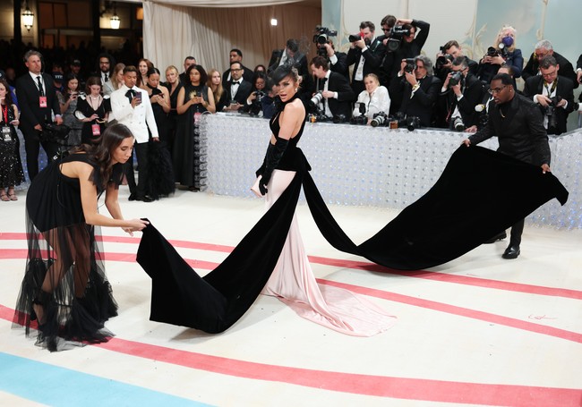 Alih-alih bunga seperti beberapa MET Gala sebelumnya, pembatas untuk pers di karpet merah kali ini terbuat dari susunan botol air minum bekas berbahan kaca. Ide tersebut datang dari Tadao Ando, temat Karl sekaligus arsitek ternama yang ditunjuk untuk mendesain instalasi pameran Karl Lagerfeld: A Line of Beauty.  (Foto: Christopher Polk/WWD via Getty Images)