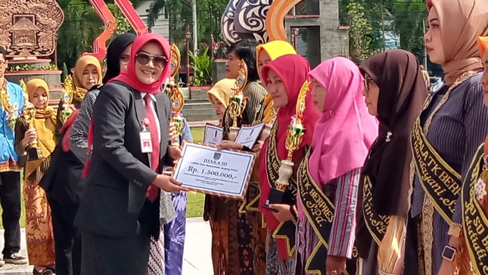 Bupati Klaten Sri Mulyani menyerahkan penghargaan ke guru dan kepala sekolah berprestasi.
