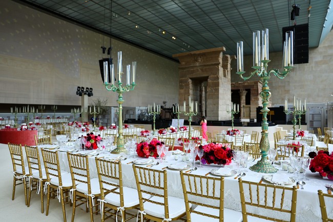 Saat menikmati hidangan, para tamu juga dimanjakan table setting yang menawan dengan aksen merah yang manis dari rangkaian bunga. (Foto: Arturo Holmes/MG23/Getty Images for The Met Museum/Vogue)