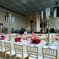 Saat menikmati hidangan, para tamu juga dimanjakan table setting yang menawan dengan aksen merah yang manis dari rangkaian bunga. (Foto: Arturo Holmes/MG23/Getty Images for The Met Museum/Vogue)