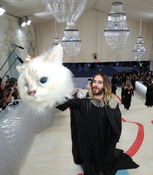 Botol tersebut juga disulap menjadi lampu kristal yang menggantung di atas karpet merah. Tadao memilih botol bekas karena bersinggungan dengan sosok Karl yang visioner dan selalu berorientasi pada masa depan. Belakangan, mendaur ulang dipandang sebagai tren gaya hidup yang kekinian.  “Ini mengingatkan pada cinta Karl akan sesuatu yang modern,” tulis Eaddy Kiernan, salah seorang editor Vogue, yang ikut terlibat mempersiapkan MET 2023. (Foto: Kevin Mazur/MG23/Getty Images for The Met Museum/Vogue)