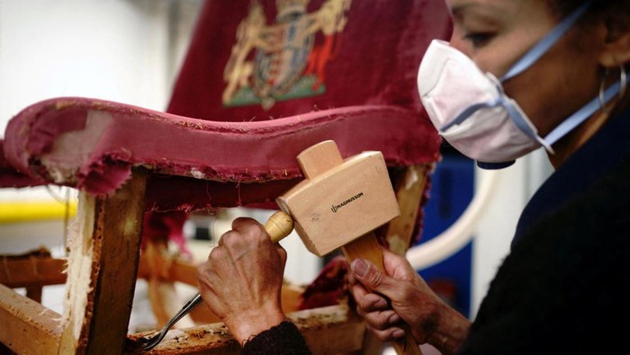 A upholsterer works on restoring a throne chair at Marlborough House, ahead of the Coronation of King Charles and Camilla, Queen Consort on May 6., in London, Britain February 17, 2023.  Victoria Jones/Pool via REUTERS