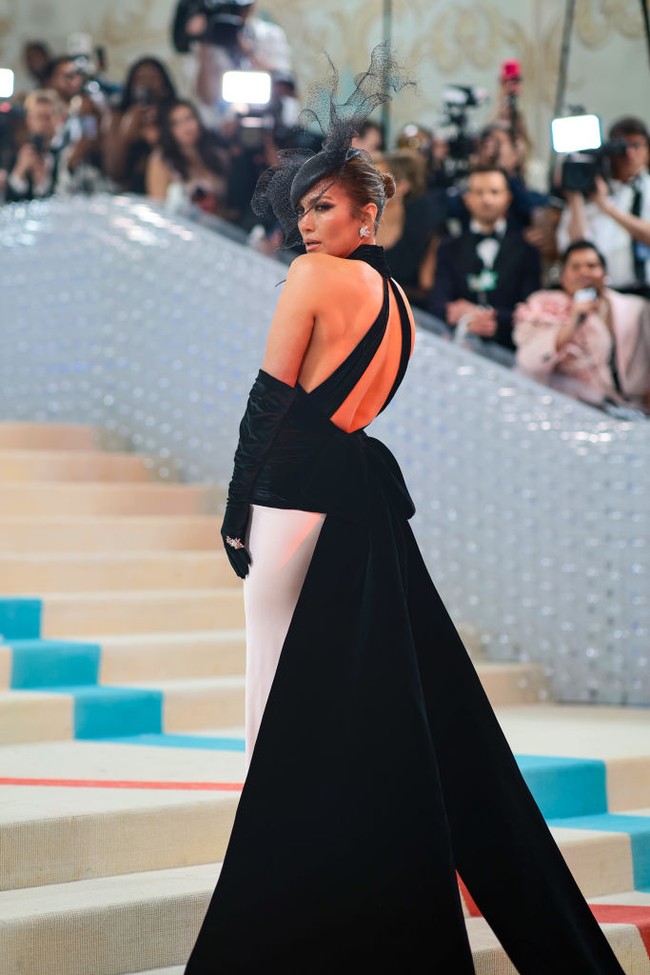 Jennifer Lopez melengkapi gayanya dengan sarung tangan sutera hitam dan topi baret tulle. Foto: Getty Images