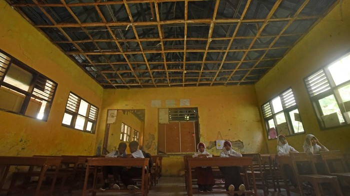 Sejumlah murid mengikuti proses belajar mengajar di ruang kelas yang plafonnya rusak di SD Negeri Sindangraksa, Walantaka, Kota Serang, Banten, Selasa (2/5/2023). Menurut Kepala Sekolah Asi Samsiah, bangunan sekolah tersebut sudah mengalami kerusakan sejak tahun 2012 pada dinding dan jenjela serta kini semakin meluas ke bagian plafon, atap, kursi, dan meja namun tak kunjung diperbaiki Pemda setempat karena tidak ada anggaran. ANTARA FOTO/Asep Fathulrahman/tom.