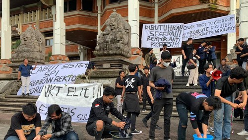 Aksi mahasiswa Unud mencuci jas almamater di depan gedung rektorat, Selasa (2/5/2023).
