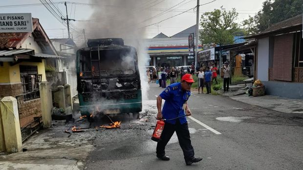 Petugas berusaha memadamkan api yang membakar mikrobus di jalan dr Sutomo, Kecamatan Majenang, Kabupaten Cilacap, Selasa (2/5/2023).