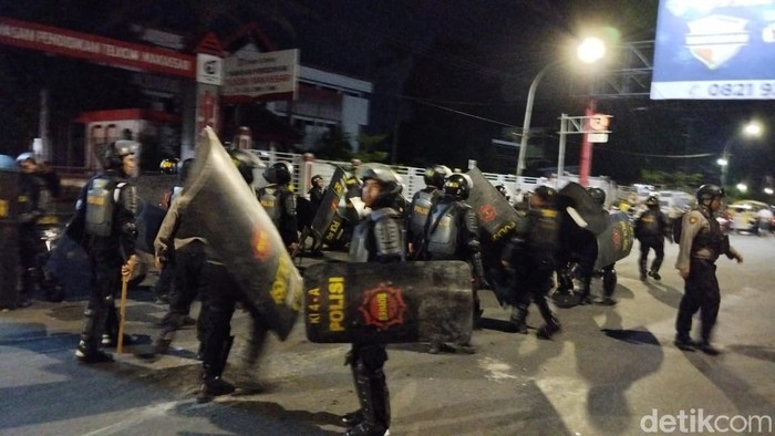 Polisi saat membubarkan massa demo yang berakhir ricuh di depan kampus UNM.