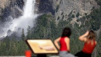 Air mengalir deras ke Air Terjun Bridalveil di Lembah Yosemite, Taman Nasional Yosemite, California, Kamis (27/4/2023). Suhu yang memanas telah membuat salju mencair yang mengakibatkan aliran air menjadi semakin deras.
