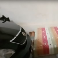 Masuk ke bagian dalam rumah, terdapat sebuah ruangan yang bisa dijadikan sebagai kamar tidur sekaligus garasi. Terlihat sebuah mobil hitam yang terparkir di dalam rumah tersebut. Berbeda dari dapur, ruangan ini sudah memiliki lantai yang dikeramik. Foto: YouTube/Kromo Chanel