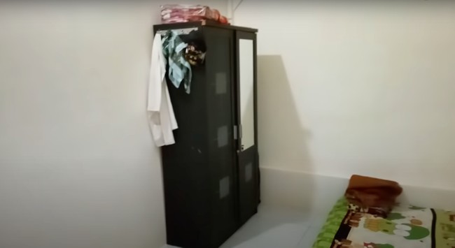 Di sebelah garasi terdapat kamar yang berisi tempat tidur dan sebuah lemari. Kamar tersebut juga tampak nyaman dengan dinding yang dicat putih dan lantai yang sudah menggunakan keramik. Foto: YouTube/Kromo Chanel