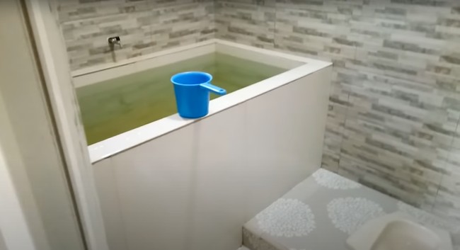 Begini penampakan kamar mandi kedua di dalam rumah yang terletak di dusun Sumber Mulyo, desa Kebonharjo, kecamatan Jatirogo, kabupaten Tuban. Sama-sama sudah seluruhnya dikeramik, kamar mandi yang satu ini seikit lebih besar dan dilengkapi dengan kloset jongkok. Foto: YouTube/Kromo Chanel