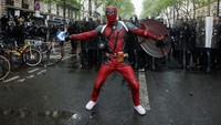 Seorang pria mengenakan kostum Deadpool menghadiri peringatan May Day di Paris, Prancis 1 Mei 2023.