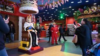 Pengunjung mengambil gambar figur LEGO ukuran penuh yang menggambarkan Raja Inggris Charles III di toko mainan Hamleys di pusat kota London, Kamis (27/4/2023). Raja LEGO duduk di Singgasana Kerajaannya.  