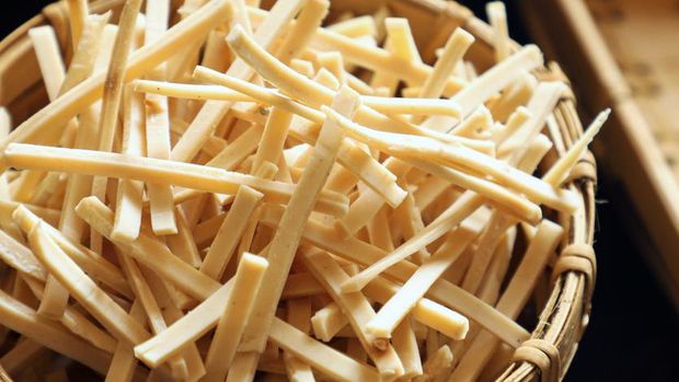 Kerupuk Stik Bawang. Stick cracker of garlic and tapioca paste that's shaped into thin sticks. The cracker is placed in a woven bamboo container and arranged among other crackers.