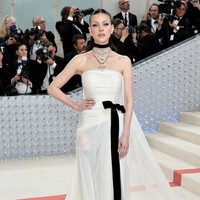 Istri Brooklyn Beckham, Nicola Peltz, tampil dengan gaya monokrom mengenakan gaun strapless putih yang diberi aksen pita hitam di bagian pinggang. Gaun off-white berbahan chifon ini merupalan koleksi Valentino. Foto: Getty Images