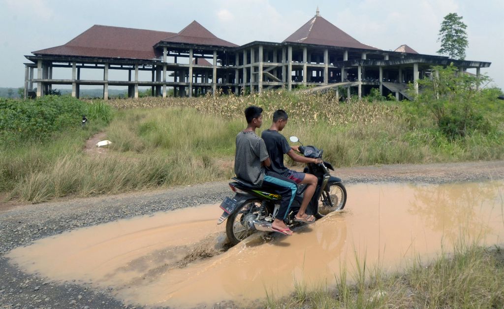 Pengendara mobil melintas di antara jalan berlubang yang tergenang air di jalan terusan Ryacudu Jati Agung, Lampung Selatan Lampung, Rabu (3/5/2023). Sejumlah titik jalur akses menuju Kota Baru Lampung, mengalami kerusakan sehingga membahayakan kesalamatan pengendara yang nelintas jalur tersebut.