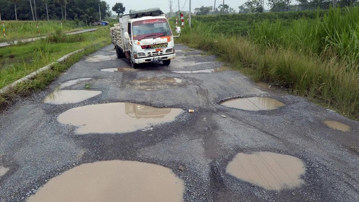 Pengendara mobil melintas di antara jalan berlubang yang tergenang air di jalan terusan Ryacudu Jati Agung, Lampung Selatan Lampung, Rabu (3/5/2023). Sejumlah titik jalur akses menuju Kota Baru Lampung, mengalami kerusakan sehingga membahayakan kesalamatan pengendara yang nelintas jalur tersebut.