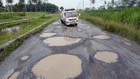 Pengendara melintas di jalan terusan Ryacudu Jati Agung, Lampung Selatan, yang rusak, Rabu (3/5/2023).