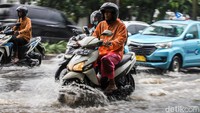 Sejumlah pesepeda motor tampak menerobos genangan. 