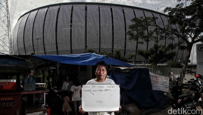 Menyentuh Hati, Ini Ungkapan Warga Kampung Bayam Menagih Janji Sejumlah warga korban penggusuran Kampung Bayam berpose dengan tulisan di depan Jakarta International Stadium, Papanggo, Jakarta Utara, Rabu (3/5/2023).