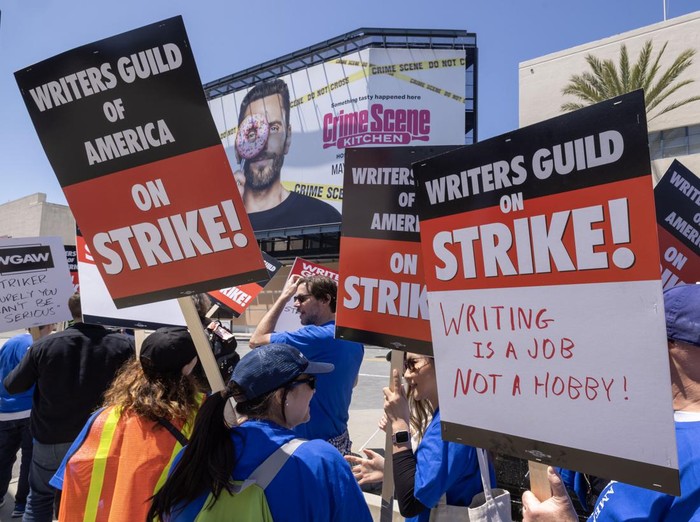 LOS ANGELES, CA - MAY 02: People picket outside of Paramount Pictures on the first day of the Hollywood writers strike on May 2, 2023 in Los Angeles. Scripted TV series, late-night talk shows, film and streaming productions are being interrupted by the Writers Guild of America (WGA) strike. In 2007 and 2008, a WGA strike shut down Hollywood productions for 100 days, costing the local economy between $2 billion and $3 billion. (Photo by David McNew/Getty Images)