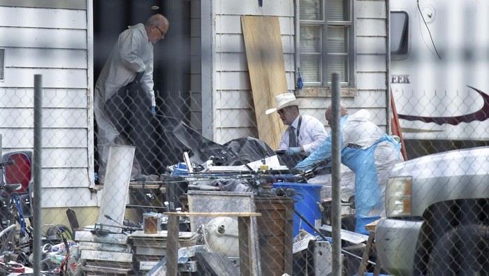Law enforcement authorities removing bodies from a scene where five people were shot the night before Saturday, April 29, 2023, in Cleveland, TX. Authorities say an 8-year-old child was among five people killed in a shooting at the home in southeast Texas late Friday night. (Yi-Chin Lee/Houston Chronicle via AP)