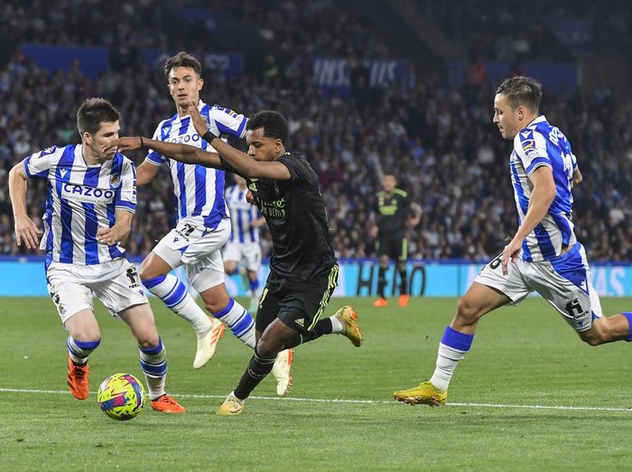 Real Madrid's Rodrygo, center, and Real Sociedad's Igor Zubeldia, left, fight for the ball during Spanish La Liga soccer match between Real Sociedad and Real Madrid at the Reale Arena stadium in San Sebastian, Spain, Tuesday, May 2, 2023. (AP Photo/Alvaro Barrientos)