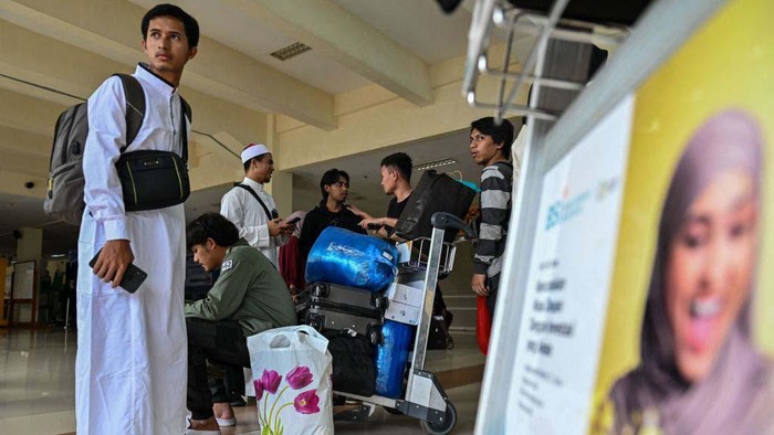 A relative hugs a man (L), part of a group of Indonesian university students evacuated from strife-torn Sudan, after his arrival at Sultan Iskandar Muda International airport in Blang Bintang, Aceh province on May 2, 2023. - Since fighting broke out on April 15, multiple foreign governments from all corners of the globe have organised road convoys, aircraft and ships to get thousands of their nationals out of Sudan, and citizens have fled overland to neighbouring countries. (Photo by CHAIDEER MAHYUDDIN / AFP) (Photo by CHAIDEER MAHYUDDIN/AFP via Getty Images)