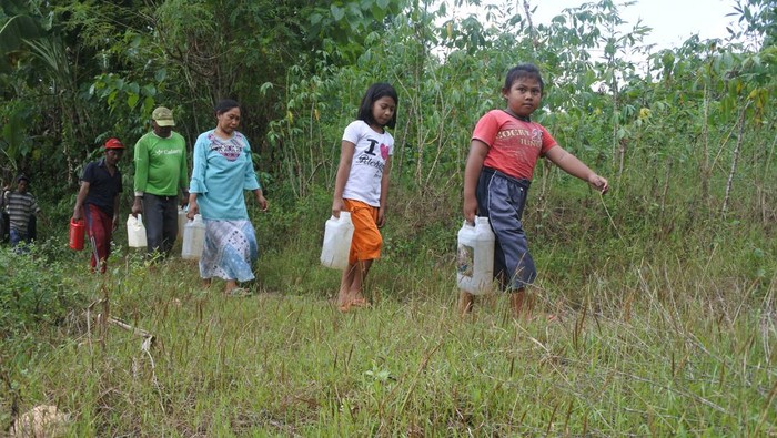 Sejumlah warga membawa jerigen berisi air yang baru diambil dari sungai yang mulai mengering debit airnya di Desa Jatisari, Arjasa, Situbondo, Jawa Timur, Rabu (3/5/2023). Sebanyak 141 kepala keluarga di desa tersebut kesulitan air bersih untuk kebutuhan minum, mandi akibat sumur bor rusak dua bulan terakhir dan terpaksa mengambil air di sungai dengan jarak satu kilometer dari rumahnya. ANTARA FOTO/Seno/hp.