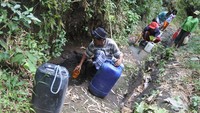 Sejumlah warga mengambil air di sungai yang mulai mengering debit airnya di Desa Jatisari, Arjasa, Situbondo, Jawa Timur, Rabu (3/5/2023). Warga menampung air dengan membawa jerigen.