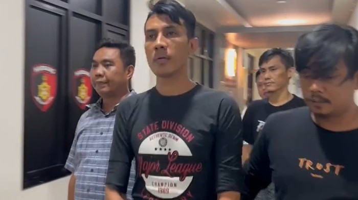 Ariyanto (tengah) ditangkap polisi usai aksi viral onani di depan rumah warga di Kemayoran, Jakpus.