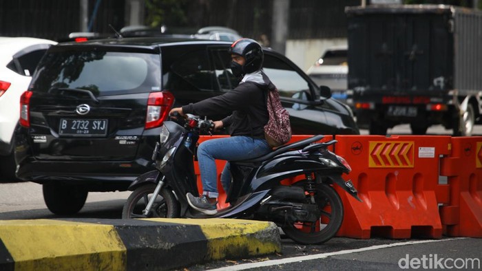 Pesepeda motor menerobos barrier untuk berputar balik menjelang jalan masuk ke JLNT Antasari, Jakarta, Kamis (4/5/2023).